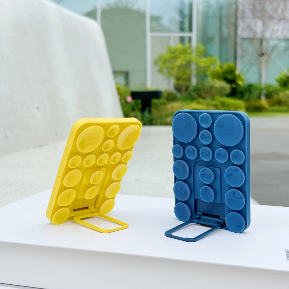 Silicone suction mobile phone folding stand holder by TecHub, showing a black flexible holder attached to a surface for hands-free use.